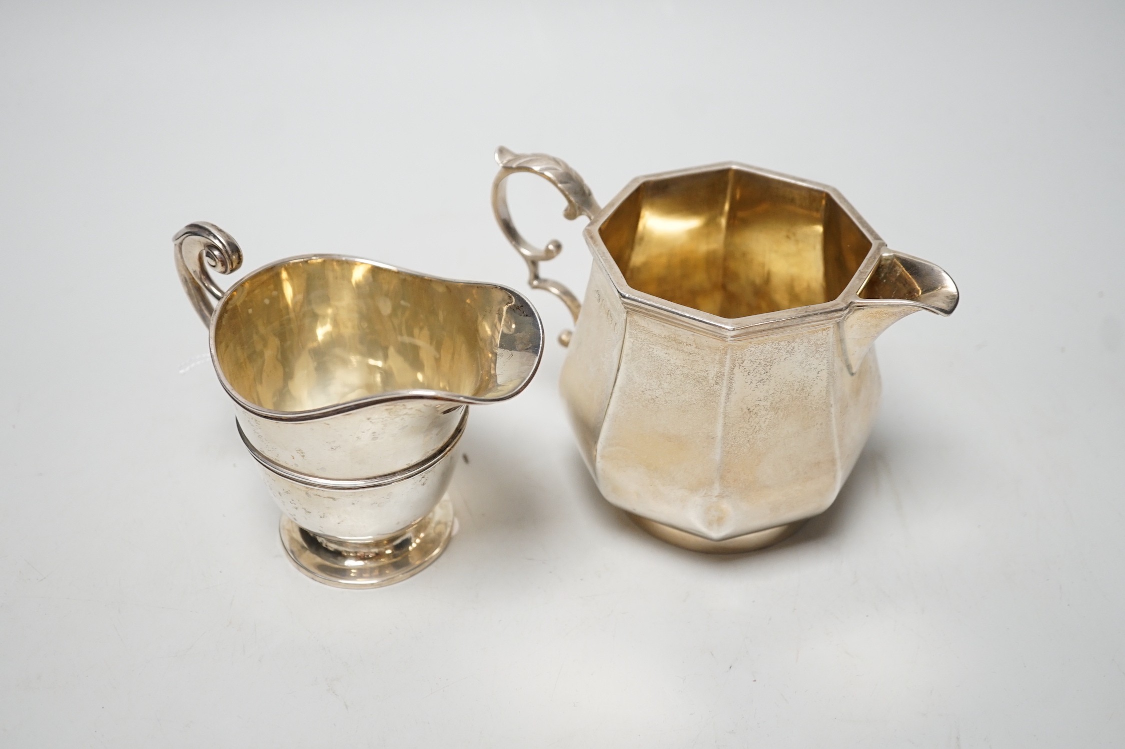 A George V panelled silver cream jug, by Elkington & Co, Birmingham, 1926, height 10cm and a late Victorian silver cream jug, London, 1899, 12.6oz.